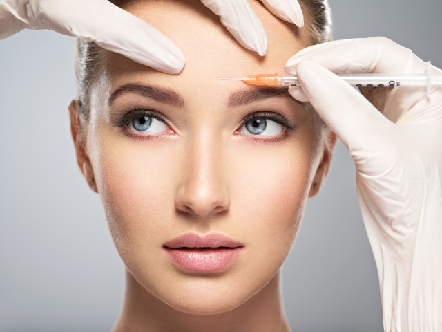 woman getting cosmetic botox injection in forehead