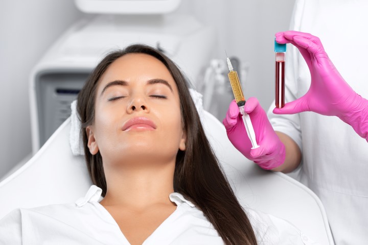 Beautician will do PRP therapy for the face against wrinkles and against hair loss of a beautiful woman in beauty salon.Doctor holds test tubes with venous blood and blood plasma.Cosmetology concept.